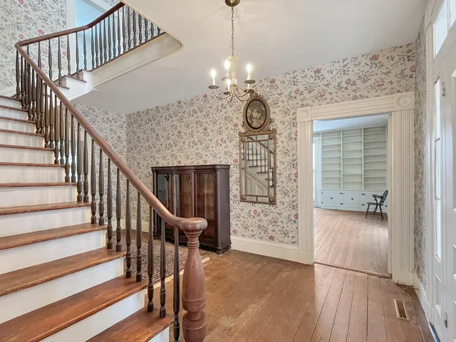 a view of a hallway with wooden floor and staircase