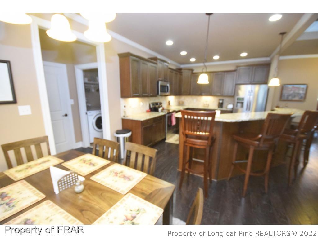 1804 Micahs Way North Spring Lake, NC 28390 - Photo 24 of 30 a living room with stainless steel appliances kitchen island granite countertop furniture and a dining table