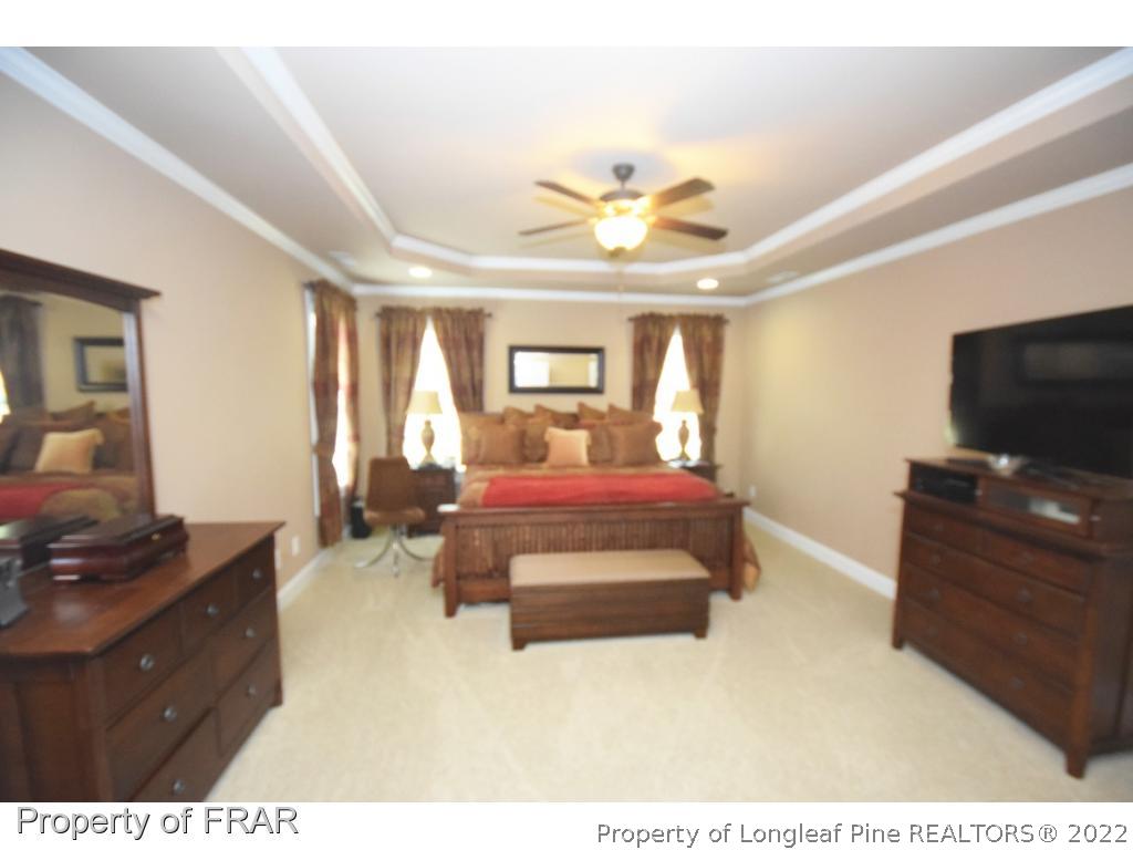 1804 Micahs Way North Spring Lake, NC 28390 - Photo 25 of 30 a spacious bedroom with a bed and a flat screen tv