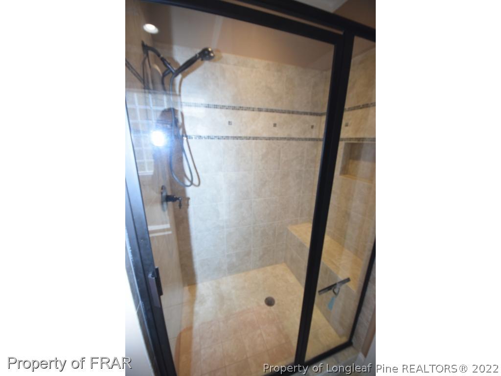 1804 Micahs Way North Spring Lake, NC 28390 - Photo 28 of 30 a bathroom with a glass shower door and a sink