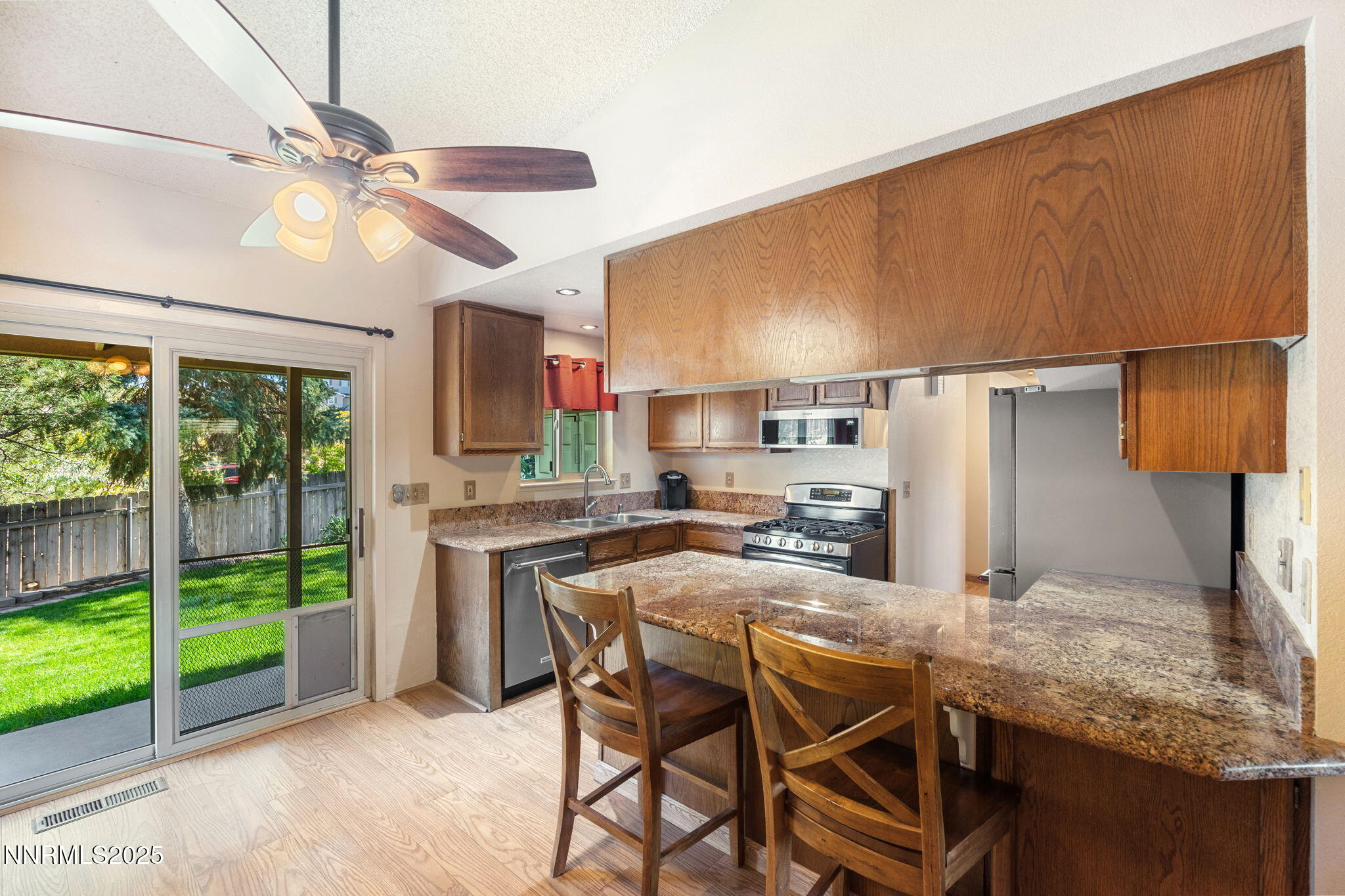 8678 Strutter Way Reno, NV 89506 - Photo 18 of 38 a kitchen with stainless steel appliances granite countertop a table chairs and a refrigerator