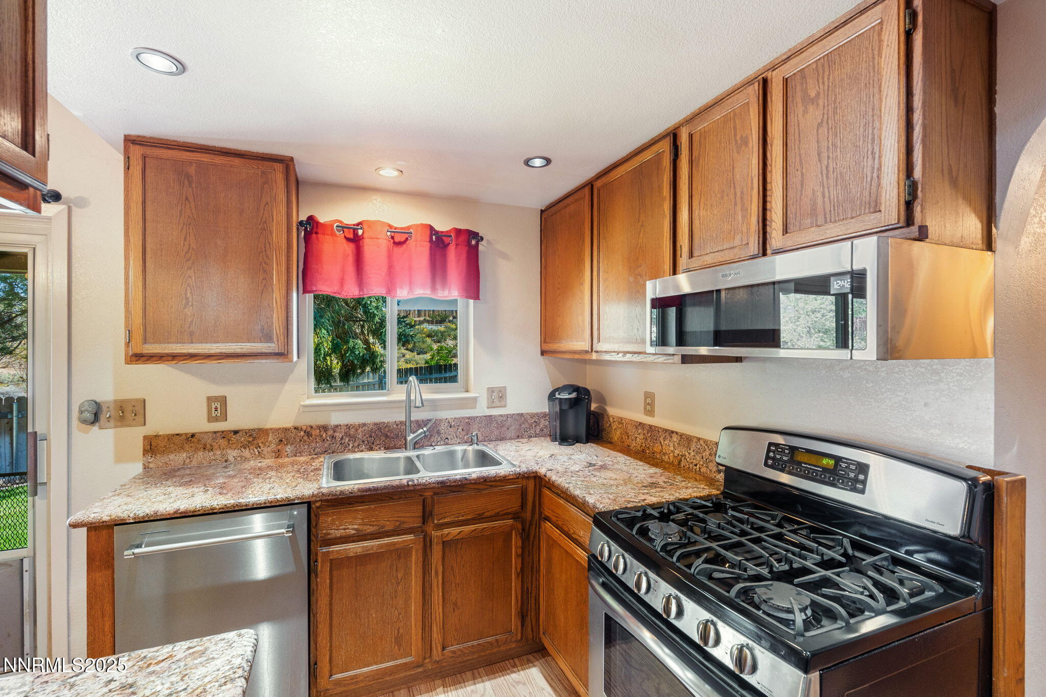 8678 Strutter Way Reno, NV 89506 - Photo 21 of 38 a kitchen with stainless steel appliances granite countertop a stove a sink and a microwave