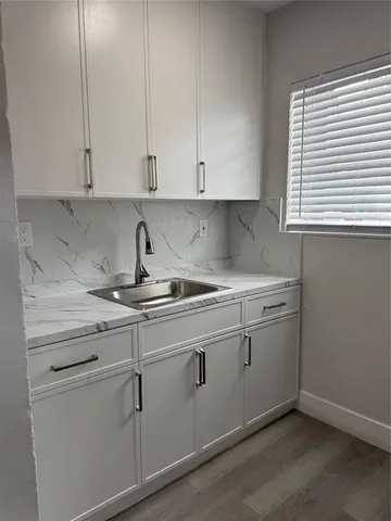a kitchen with white cabinets and a sink