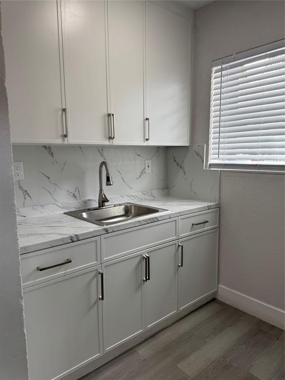 731 Northwest 56th Street, Unit 101 Miami, FL 33127 - Photo 2 of 11 a kitchen with white cabinets and a sink
