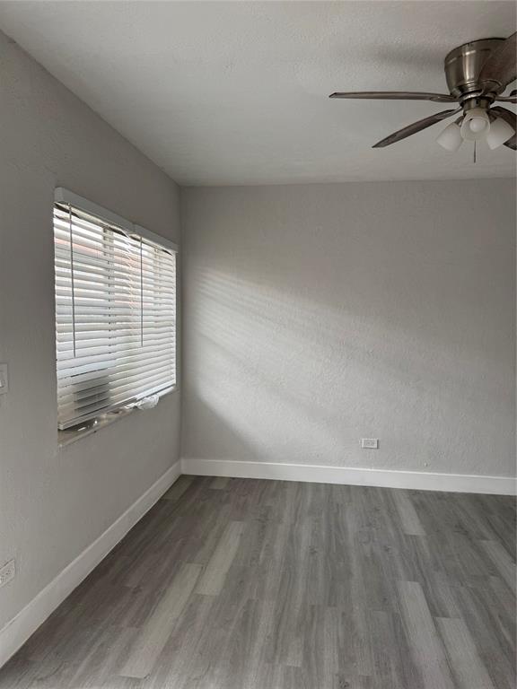 731 Northwest 56th Street, Unit 101 Miami, FL 33127 - Photo 5 of 11 wooden floor in an empty room with a window