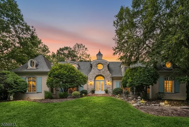 a front view of a house with a yard and a tree
