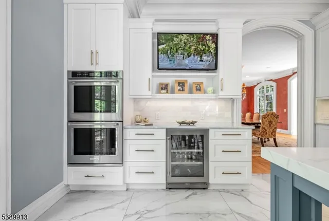 a view of kitchen with stainless steel appliances cabinets and window