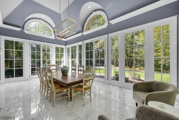 a dining room with furniture a large window and a chandelier