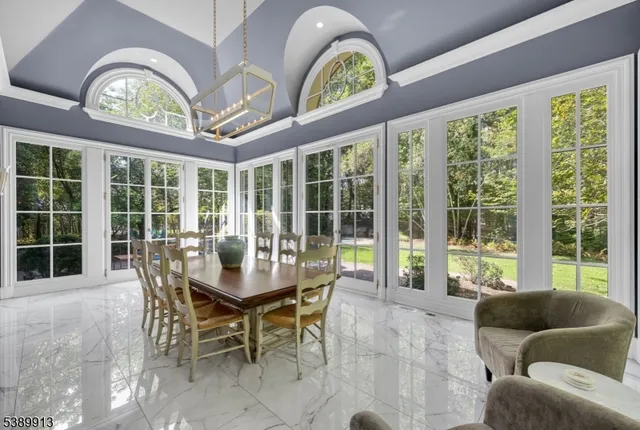 a dining room with furniture a large window and a chandelier
