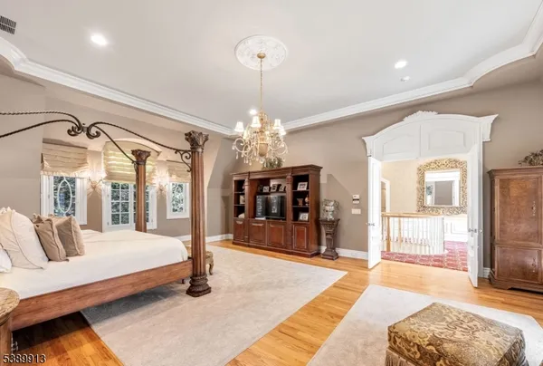 a spacious bedroom with a large bed and a chandelier