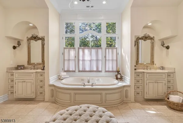 a spacious bathroom with a tub sink and mirror