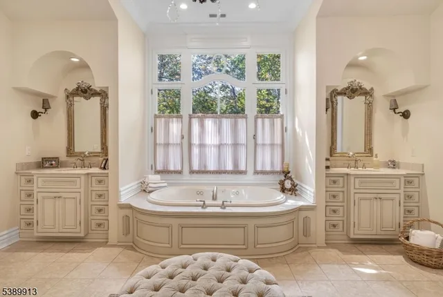 a spacious bathroom with a tub sink and mirror