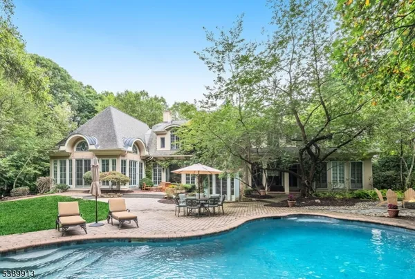 a front view of a house with garden and sitting area