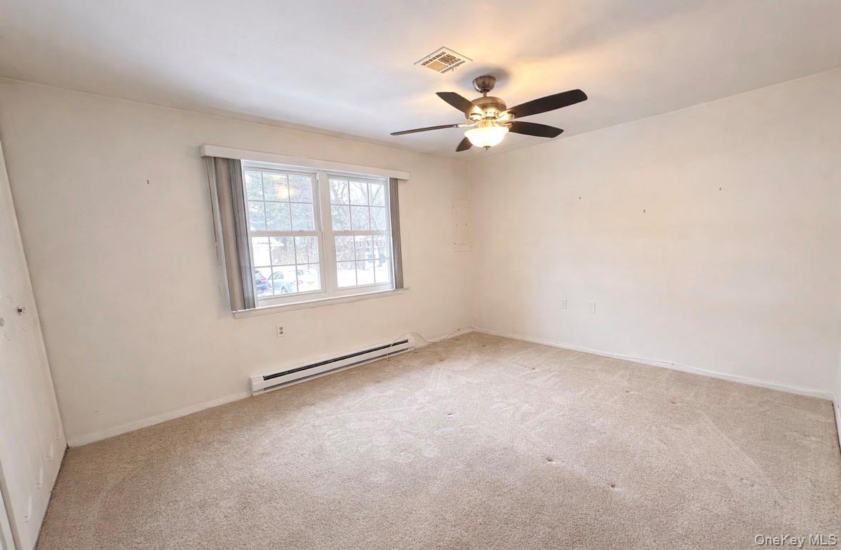 306 Torquay Court, Unit E Ridge, NY 11961 - Photo 12 of 12 an empty room with windows and fan