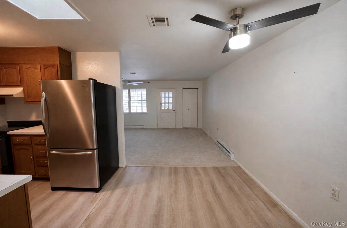 306 Torquay Court, Unit E Ridge, NY 11961 - Photo 7 of 12 a view of a refrigerator in kitchen and wooden floor