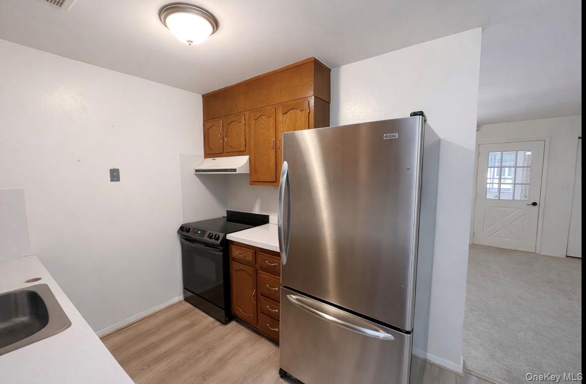 306 Torquay Court, Unit E Ridge, NY 11961 - Photo 8 of 12 a metallic refrigerator freezer sitting in a kitchen