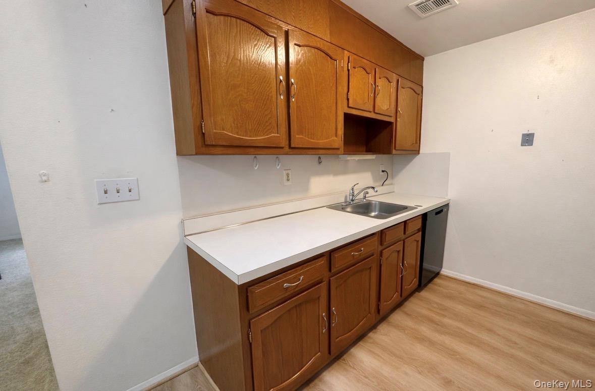 306 Torquay Court, Unit E Ridge, NY 11961 - Photo 9 of 12 a utility room with wooden floor