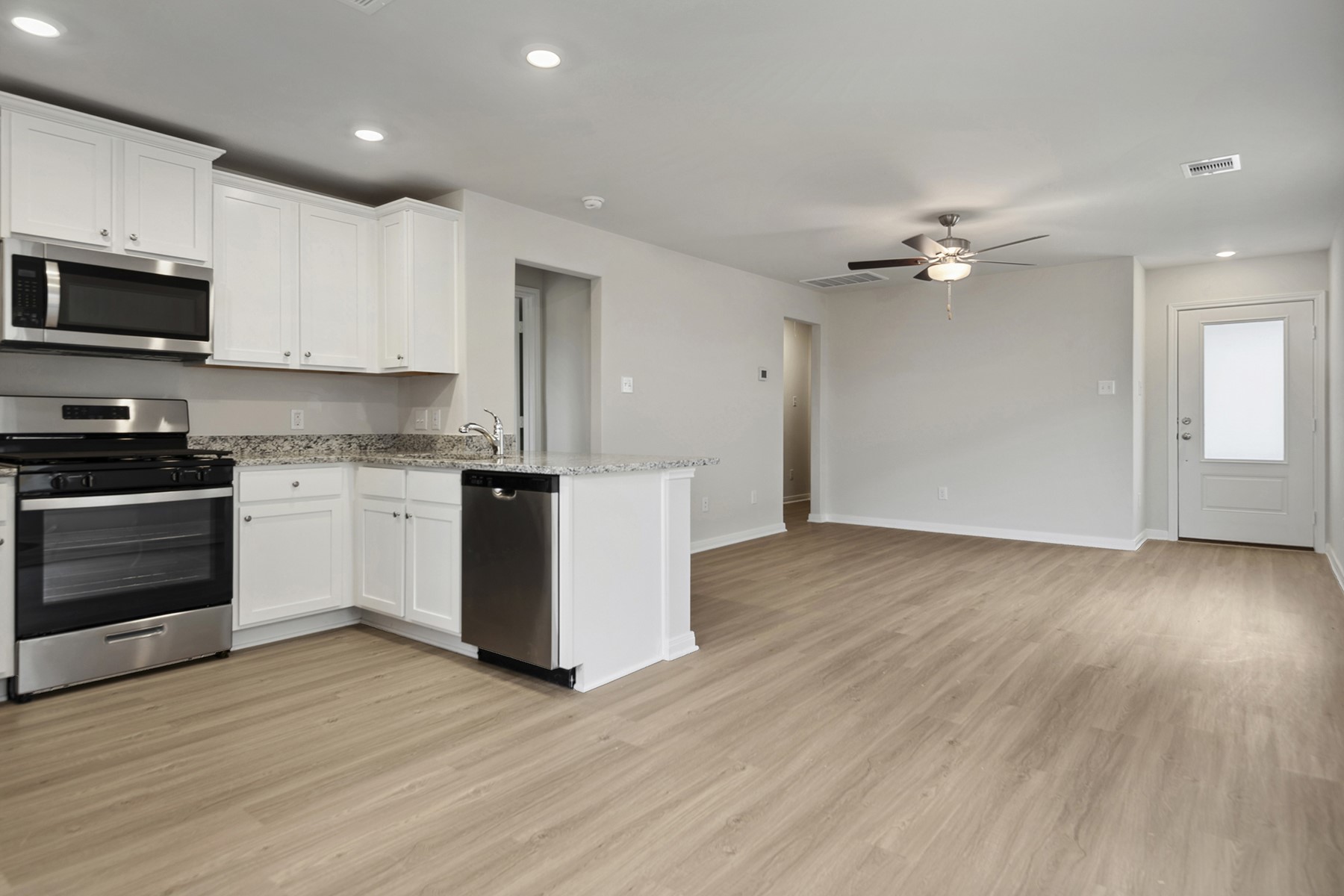 15866 Berry Hl Drive Conroe, TX 77303 - Photo 7 of 20 a kitchen with stainless steel appliances granite countertop a stove top oven a sink dishwasher and a refrigerator with wooden floor