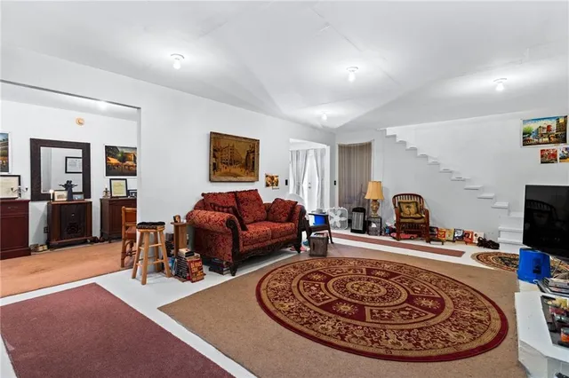a living room with furniture a flat screen tv and a rug