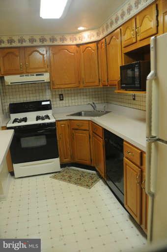 8173 Mid Haven Road Baltimore, MD 21222 - Photo 11 of 30 a kitchen with stainless steel appliances granite countertop a stove a sink and a microwave