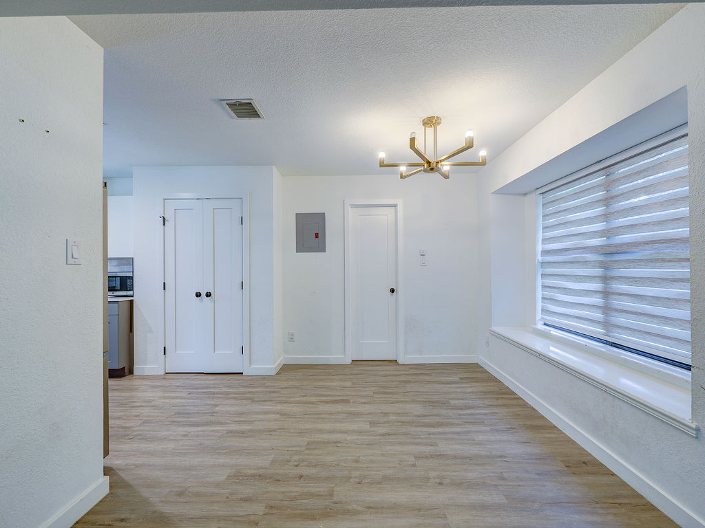 5842 Secrest Drive Austin, TX 78759 - Photo 35 of 40 A warm, sun-drenched living space featuring durable plank flooring and contemporary lighting.