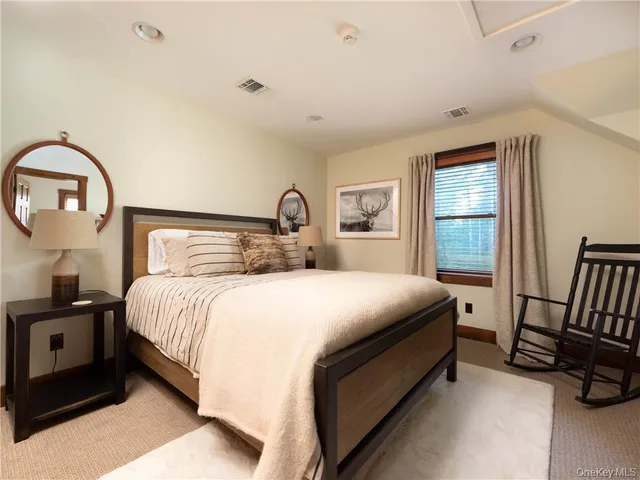 a bedroom with a bed and a large window