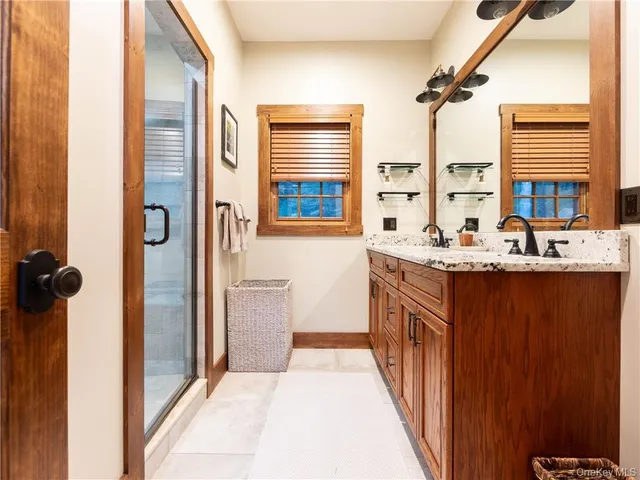 a en suite bathroom with a double vanity sink a mirror and a shower