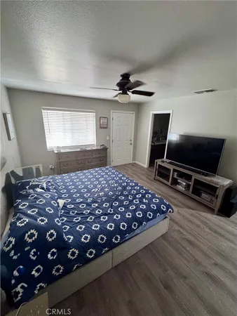 a bedroom with a bed dresser and a flat screen tv