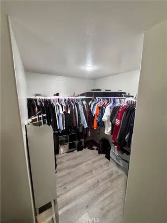 a view of walk in closet with clothes and shoes