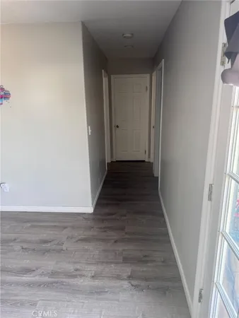 a view of a hallway with wooden floor