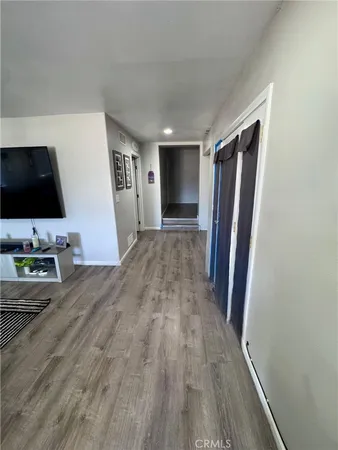 a view of a livingroom with wooden floor and a flat screen tv