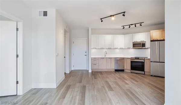a kitchen with kitchen island white cabinets and stainless steel appliances