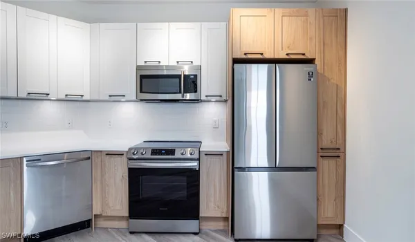 a kitchen with stainless steel appliances granite countertop a refrigerator stove and microwave