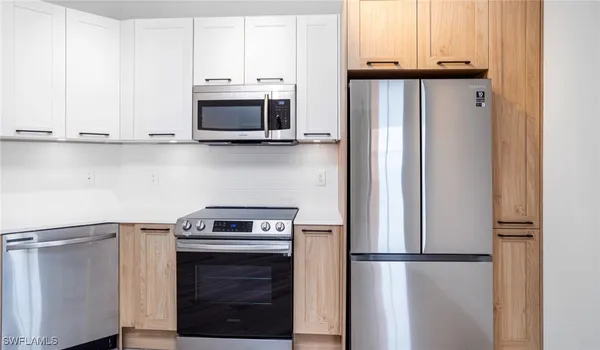 a kitchen with granite countertop white cabinets and stainless steel appliances