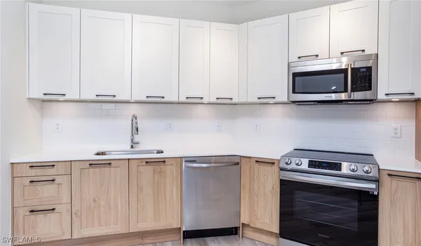 a kitchen with granite countertop white cabinets and stainless steel appliances