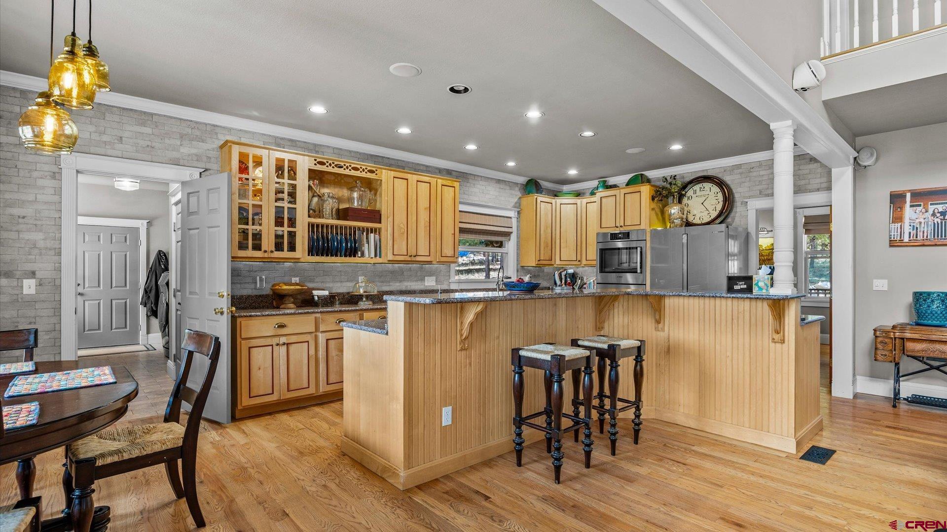 269 Puma Lane Ridgway, CO 81432 - Photo 17 of 36 a kitchen with stainless steel appliances granite countertop a refrigerator a stove top oven and a dining table with wooden floor