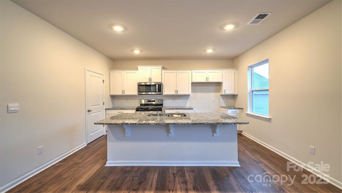 356 Wheatfield Road Fletcher, NC 28732 - Photo 5 of 25 a large kitchen with stainless steel appliances granite countertop a sink and wooden floor