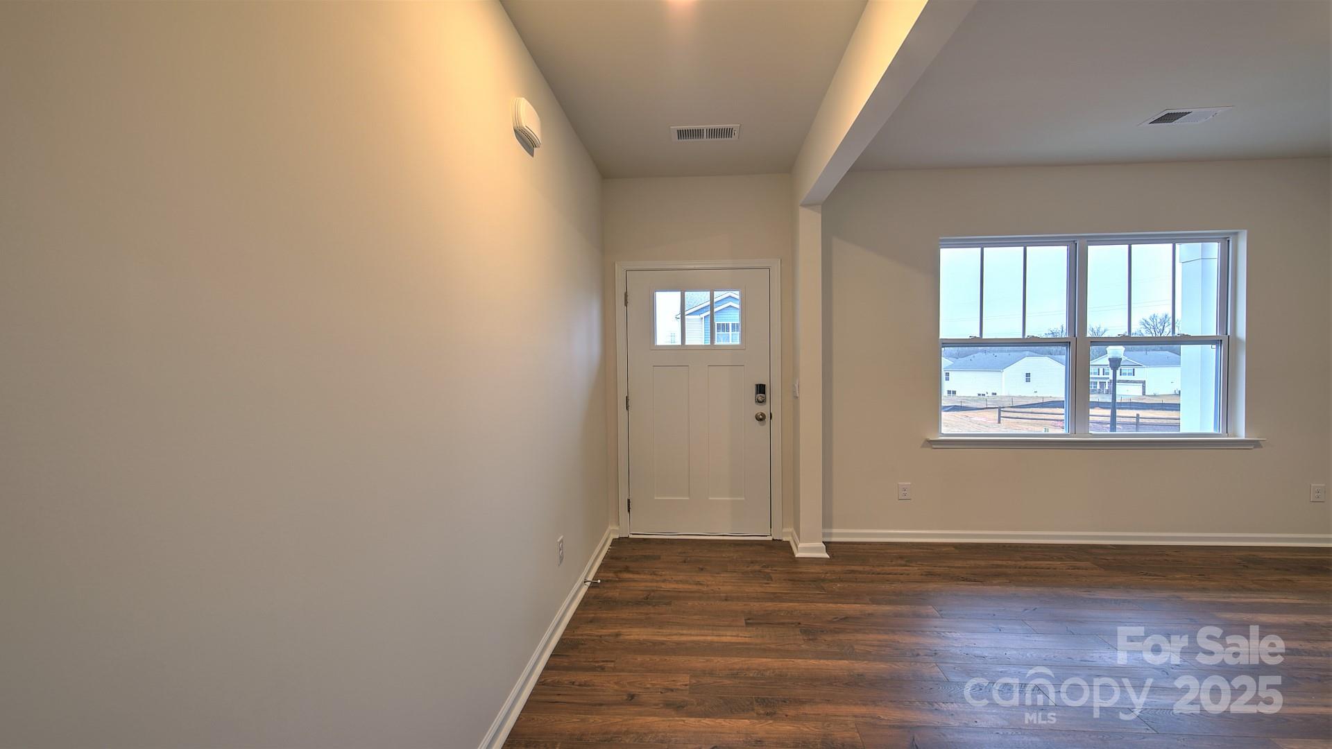 356 Wheatfield Road Fletcher, NC 28732 - Photo 8 of 25 a view of an empty room with wooden floor and a window