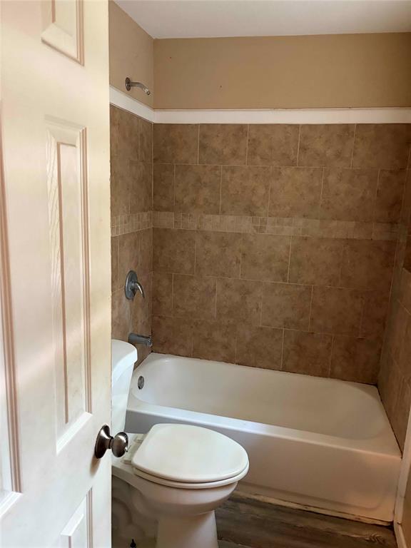 701 West Colorado Street Groesbeck, TX 76642 - Photo 10 of 12 Full bath featuring dark wood-type flooring and shower combination