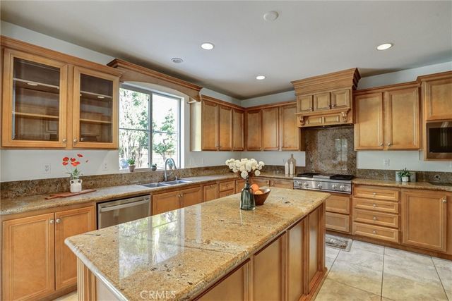 a kitchen with a sink a counter top space cabinets and stainless steel appliances