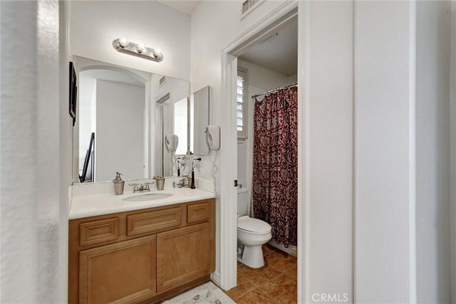 a bathroom with a double vanity sink mirror and toilet