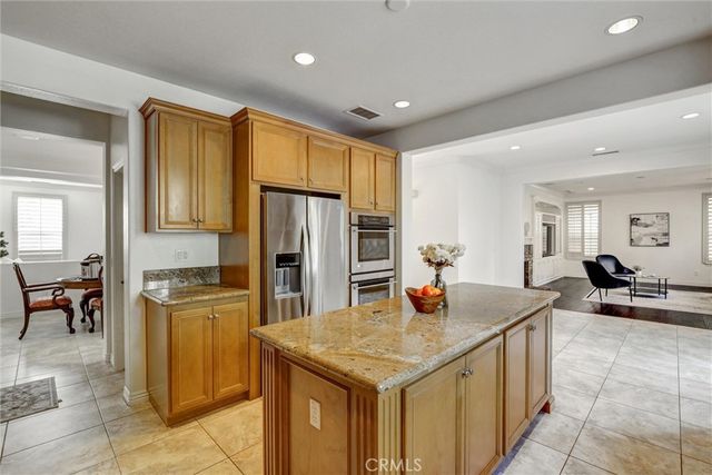 a kitchen with stainless steel appliances granite countertop a stove refrigerator and cabinets