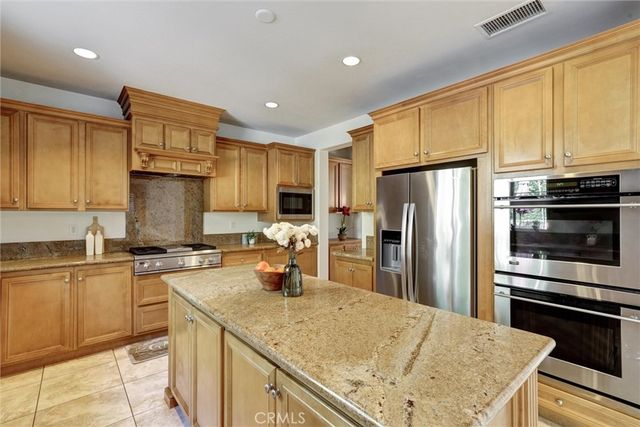 a kitchen with a refrigerator a stove a sink cabinets and wooden floor