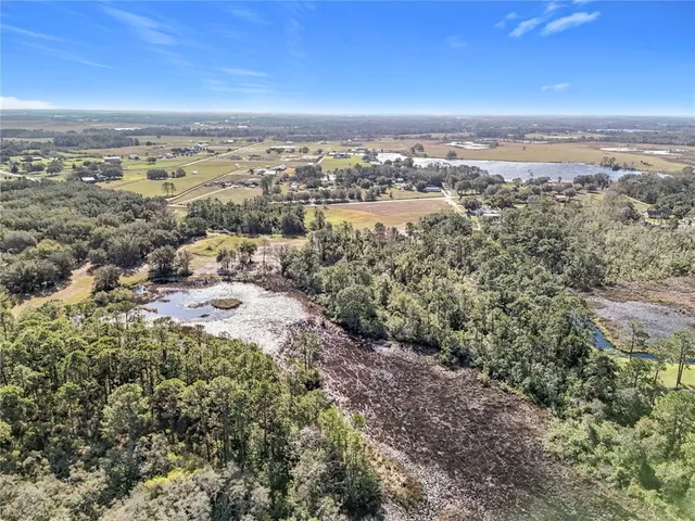 an aerial view of ocean and residential houses with outdoor space