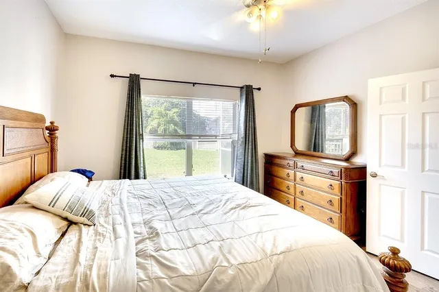a bedroom with a large bed and a flat tv screen on dresser