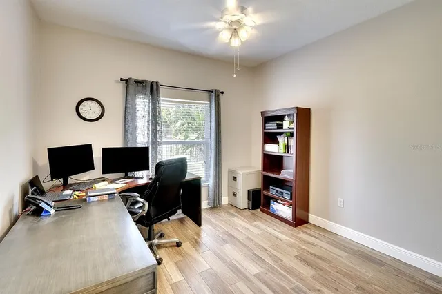 a view of a workspace with furniture and a window