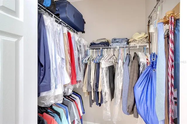 a view of walk in closet with clothes