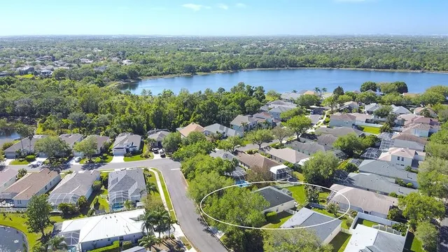 an aerial view of a house with a lake view and mountain view in back