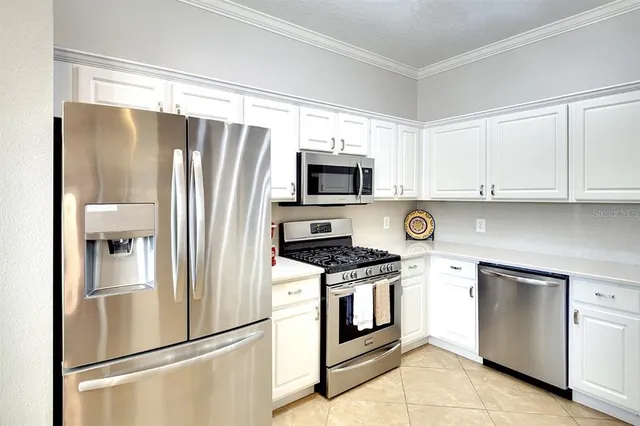 a kitchen with stainless steel appliances granite countertop a refrigerator sink and stove