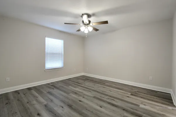 wooden floor in an empty room with a window